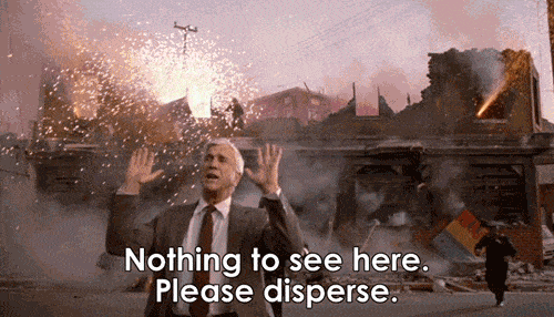 Leslie Nealson in The Naked Gun with subtitles 'Nothing to see here, please disperse' while a firework factory explodes behind him.